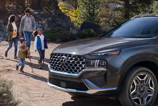 Hyundai SUV parked outdoors with family nearby