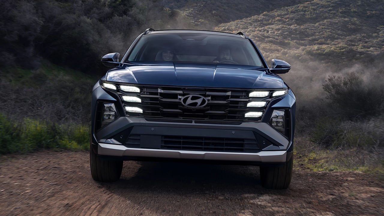 Vue avant du Hyundai Tucson 2026 sur route de gravier en pleine puissance