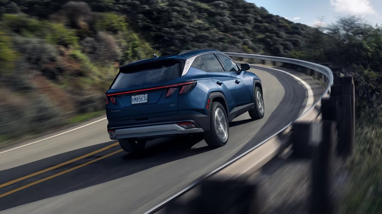 Vue arrière d'un Hyundai Tucson 2026 sur route en pleine puissance