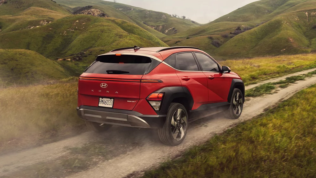 Vue arrière du Hyundai Kona électrique 2026 sur chemin de terre en pleine puissance