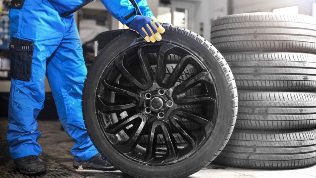technicien avec un pneu dans un garage